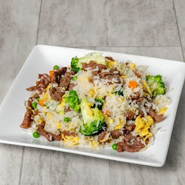 Golden China Restaurant's beef fried rice with broccoli, peas, carrots, and scrambled egg on a white plate.