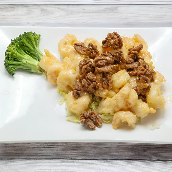 Honey walnut shrimp with broccoli and lettuce on a white rectangular plate from Golden China Restaurant.