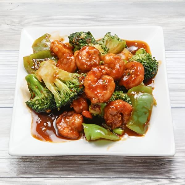Golden China Restaurant's sweet and sour shrimp with broccoli and green peppers on a white plate.